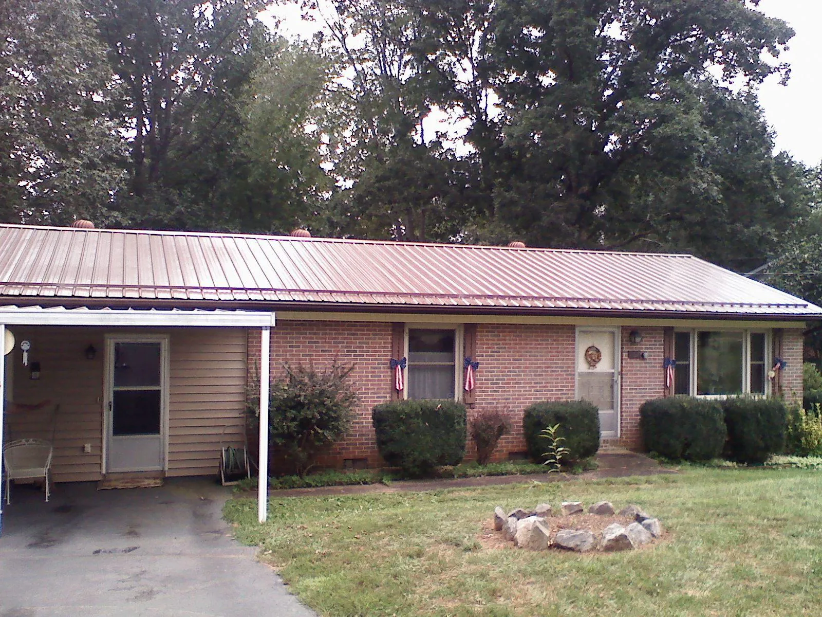 Bronze metal roof and carport on a brick ranch home — Roof Repair work by our crew in Orient